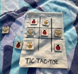 photo of the complete tic tac toe bag craft with hand painted pieces that are ladybugs and bees