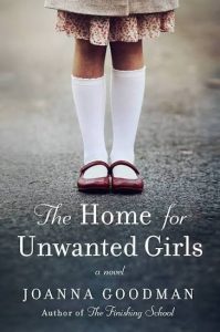 Book cover for The home for unwanted girls by joanna goodman. shows the legs of a little girl standing on a road with a pink skirt below her knees and high white socks and red shoes.
